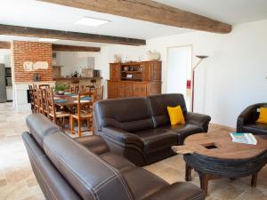 a living room with a leather couch and a table at Gîte spacieux à Happonvilliers avec jardin privatif, accueil jusqu'à 14 personnes, animaux admis - FR-1-581-139 in Happonvilliers