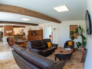 a living room with a leather couch and a table at Gîte spacieux à Happonvilliers avec jardin privatif, accueil jusqu'à 14 personnes, animaux admis - FR-1-581-139 in Happonvilliers
