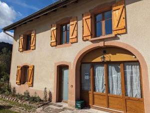 a house with wooden doors and a balcony at Chambre climatisée avec salle d'eau privative et accès jardin - FR-1-589-664 in Rehaupal +5 photos