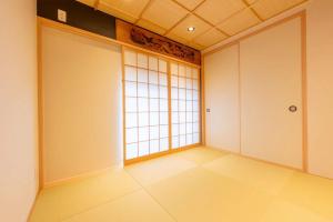 an empty room with two doors and a window at 三十三Tuchi in Kyoto