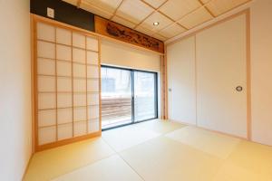 an empty room with a large window and white walls at 三十三Tuchi in Kyoto +8 photos