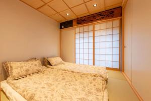 a bedroom with a bed and a window at 三十三Tuchi in Kyoto