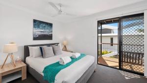 Un dormitorio con una cama y un balcón. en Jetty Escape Townhouse - Cafes, Parks, Beach, en Coffs Harbour