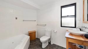 Un baño blanco con inodoro y lavabo. en Jetty Escape Townhouse - Cafes, Parks, Beach, en Coffs Harbour