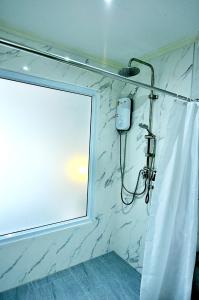 a shower with a window and a shower curtain at AM Heritage Room in Ban Hang Ta Duk