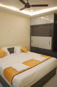 a bedroom with a large white bed with orange pillows at Nest Inn Homestay in Tirupati +53 photos
