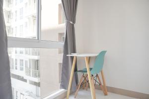 RawalembangGood Price and Nice 2BR Tokyo Riverside PIK 2 Apartment By Travelio的窗前的桌子和椅子
