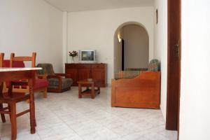 Una sala de estar llena de muebles y un televisor. en Apartamentos King's, en Quarteira