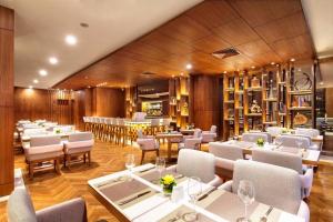 a restaurant with white tables and chairs and a bar at Deacon House Wuxi in Wuxi