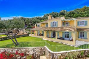 a large yellow house with a stone wall at Villa Irida in Apraos