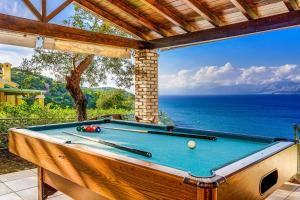 a pool table on a patio with a view of the ocean at Villa Irida in Apraos