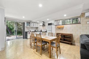 Una cocina y un comedor con mesa y sillas. en River Tree Chalet - Margaret River NEW, en Margaret River Town