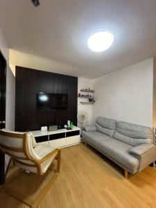 a living room with a couch and a flat screen tv at Soccour Homestay by ekc in Marilao