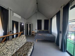 a bedroom with a bed and a couch in a room at Kataipakhaoyai in Ban Tha Chang +50 photos
