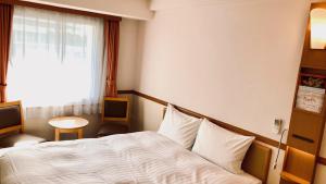 a hotel room with a bed and a window at Toyoko Inn Saitama Shintoshin in Saitama