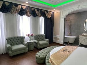 a bedroom with a bed and two chairs and a tub at Love Hotel Tô Ký in Ho Chi Minh City