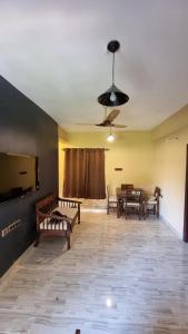 a room with benches and tables and a ceiling fan at 2bhk apartment baga with kitchen in North goa