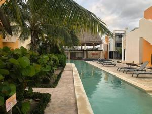 a swimming pool with chaise lounges and a resort at Villa Nicte ha - Antalea in Telchac Puerto