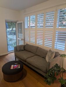 Una sala de estar con un sofá y una ventana grande. en Ground Floor Elwood village Apartment, en Melbourne