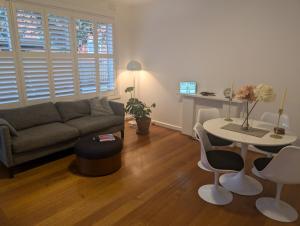 una sala de estar con un sofá y una mesa en Ground Floor Elwood village Apartment, en Melbourne
