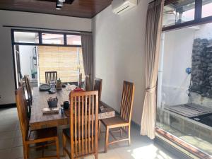 a dining room with a table and chairs and a window at Eimas Hive in Kerobokan