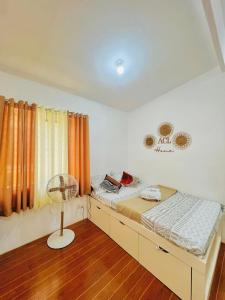 a bedroom with a bed with a fan and a window at ACL HOME -Island Staycation in Lapu Lapu City