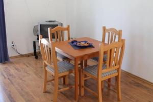 a wooden table with chairs and a plate of food on it at Apartments Lozica - Standard Studio Apartment with Terrace and Sea View in Dubrovnik +4 photos