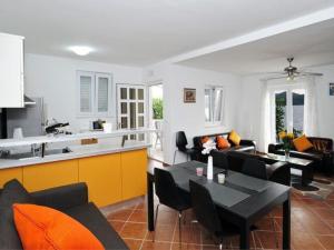 a kitchen and a living room with a table and chairs at Holiday Home Odiseja- One Bedroom Apartment with Terrace and Sea View in Brsečine