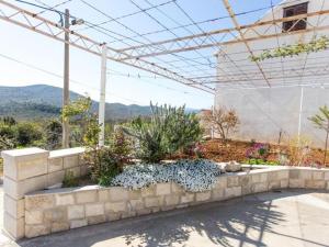 a stone retaining wall with flowers in a garden at Apartment Moja - Two Bedroom Apartment with Terrace in Zaton Doli