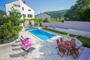 eine Terrasse mit Tisch und Stühlen und einem Pool in der Unterkunft Villa Roza - One-Bedroom Apartment with Balcony in Mokošica