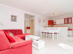a living room with a red couch and a kitchen at Apartments Matu ko Mljet - Two-Bedroom Apartment with Terrace and Sea View in Saplunara +14 photos
