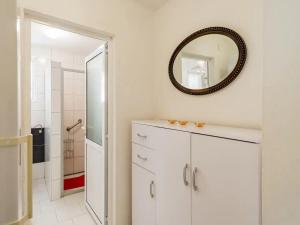 ein Badezimmer mit einem weißen Schrank und einem Spiegel in der Unterkunft Apartments Villa Pelegrin - Two Bedroom Apartment with Garden View in Zavala + 24 Fotos