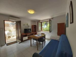 ein Schlafzimmer mit einem Bett, einem Tisch und einem Schreibtisch in der Unterkunft Apartments Villa Pelegrin - Two Bedroom Apartment with Garden View in Zavala