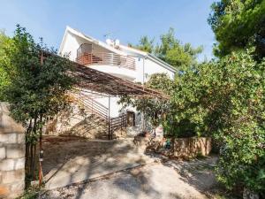 ein weißes Haus mit einem Balkon und einigen Bäumen in der Unterkunft Apartments Villa Pelegrin - Two Bedroom Apartment with Garden View in Zavala