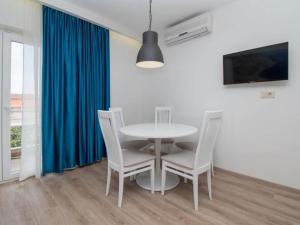 a dining room with a white table and chairs at Apartments Antonio - Comfort One-Bedroom Apartment with Balcony and Sea View - 4 in Tučepi
