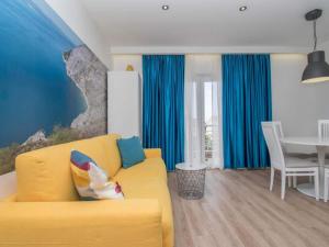 a living room with a yellow couch and a table at Apartments Antonio - Comfort One-Bedroom Apartment with Balcony and Sea View - 4 in Tučepi