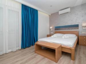 a bedroom with a bed with a blue curtain at Apartments Antonio - Comfort One-Bedroom Apartment with Balcony and Sea View - 4 in Tučepi