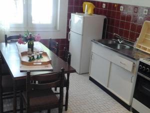 Una cocina con una mesa y un refrigerador blanco. en Apartments and Room Katja - Two Bedroom Apartment with Terrace, en Mlini