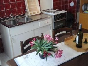 Una cocina con una mesa con un jarrón de flores encima. en Apartments and Room Katja - Two Bedroom Apartment with Terrace, en Mlini