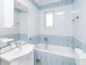 a white bathroom with a tub and a sink at Apartment Stipic Omis - Three Bedroom Apartment with Terrace in Omiš +36 photos