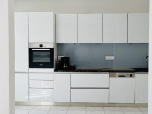 a kitchen with white cabinets and a stove top oven at Villa Tonika -Two Bedroom Apartment with Terrace A1 in Povlja