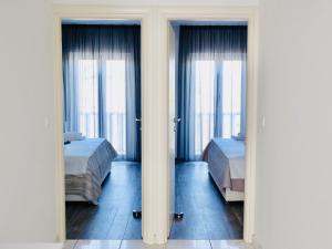 two beds in a room with two beds in front of windows at Villa Tonika -Two Bedroom Apartment with Terrace A1 in Povlja
