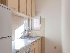a kitchen with a sink and a white refrigerator at Apartments Nena ST - One Bedroom Apartment with Balcony and Sea View A1 in Pisak +3 photos