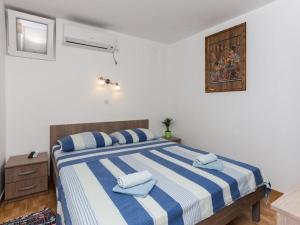 ein Schlafzimmer mit einem großen Bett mit blauen und weißen Streifen in der Unterkunft Apartments Stipo - One Bedroom Apartment with Terrace and Sea View A4 in Drače