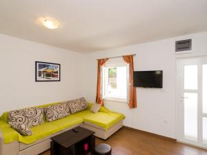 ein Wohnzimmer mit einem gelben Sofa und einem Fenster in der Unterkunft Holiday Home Jasenka Trstenik - Duplex One Bedroom Apartment with Terrace and Side Sea View in Trstenik