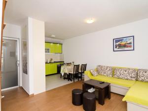 ein Wohnzimmer mit einem gelben Sofa und einer Küche in der Unterkunft Holiday Home Jasenka Trstenik - Duplex One Bedroom Apartment with Terrace and Side Sea View in Trstenik