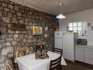 une cuisine et une salle à manger avec une table et un réfrigérateur dans l'établissement Rooms Tupina by Paulina - Superior Double Room with Balcony and Sea View Room 2, à Mlini