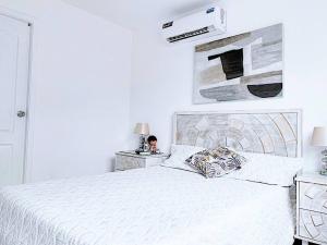 a white bedroom with a white bed and two night stands at Casa en Urbanización con Piscina Privada in Amalia +36 photos