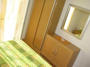 a bedroom with a bed with a mirror and a cabinet at Apartments Paloc - Standard One-bedroom Apartment with Balcony uti in Bol