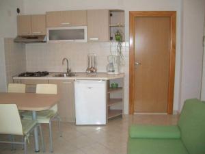 a kitchen with a sink and a table and a table and chairs at Apartments Paloc - Standard One-bedroom Apartment with Balcony uti in Bol